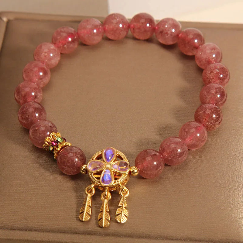 Women's strawberry quartz bracelet with a four-leaf clover dream catcher ball pendant.
