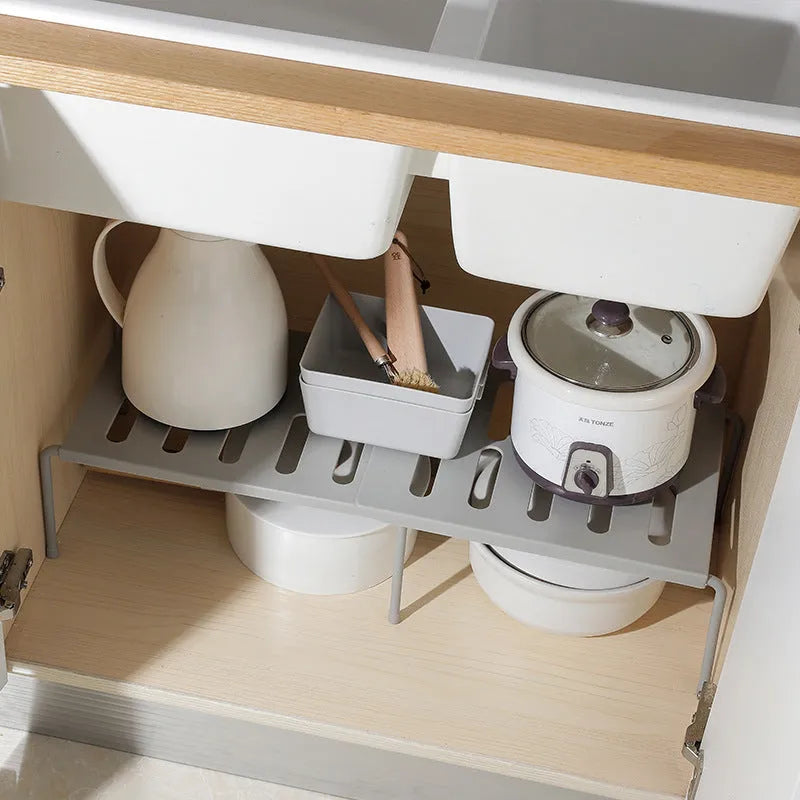 Retractable ABS rack with hollow grid design for kitchen, living room, or bathroom storage, available in grey or white