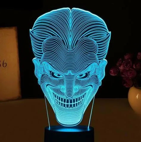 A modern 3D LED table lamp with a colourful gradient display, sitting on a square base with a USB cable.