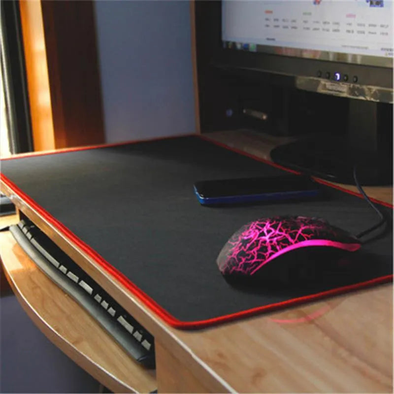 Oversized rubber mouse pad 30x60cm with stitched edge in black on a desk