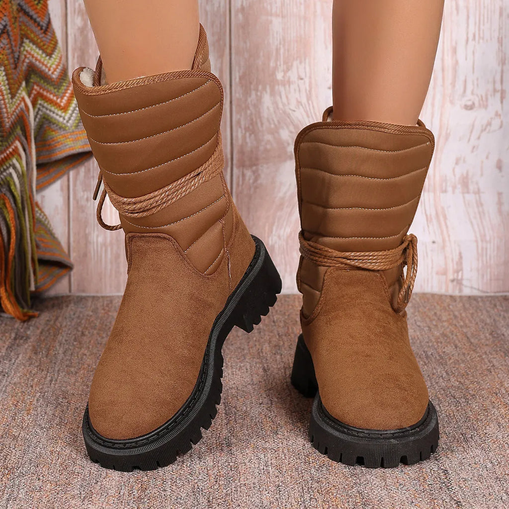 Women's black suede high-top snow boots with chunky rubber sole and lace-up design.