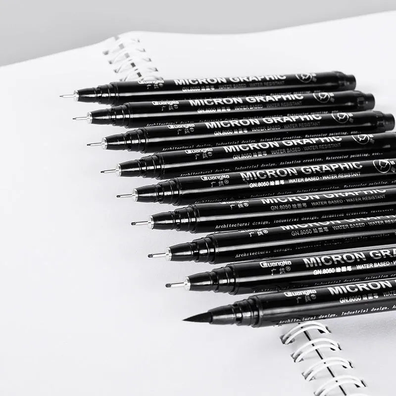 Set of 12 black comic drawing pens with various nib sizes stored in a fabric organiser bag.