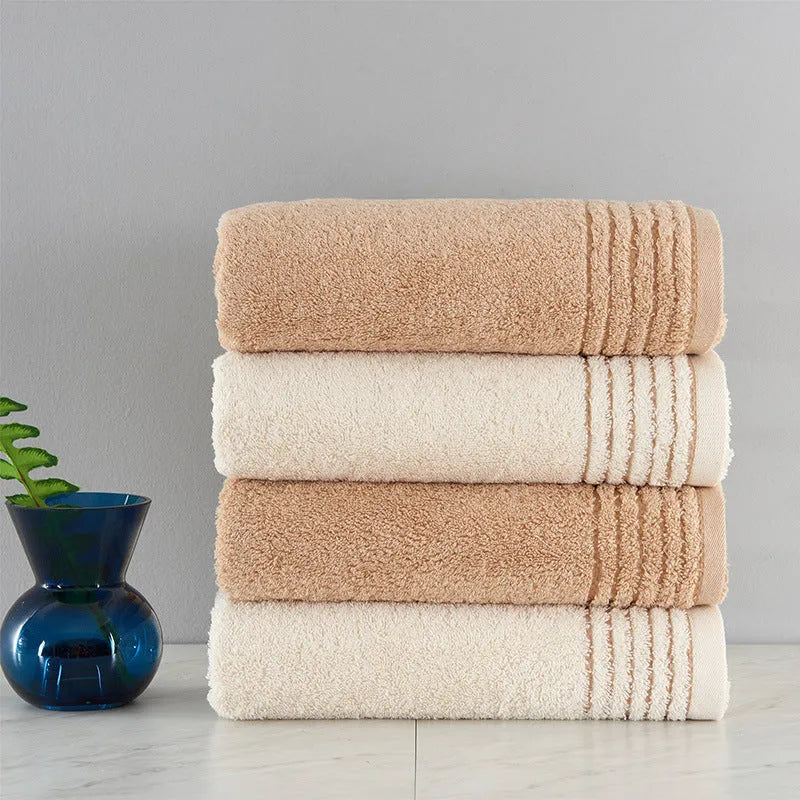 Set of three cotton towels in beige and brown colours, showing small, medium, and large sizes.