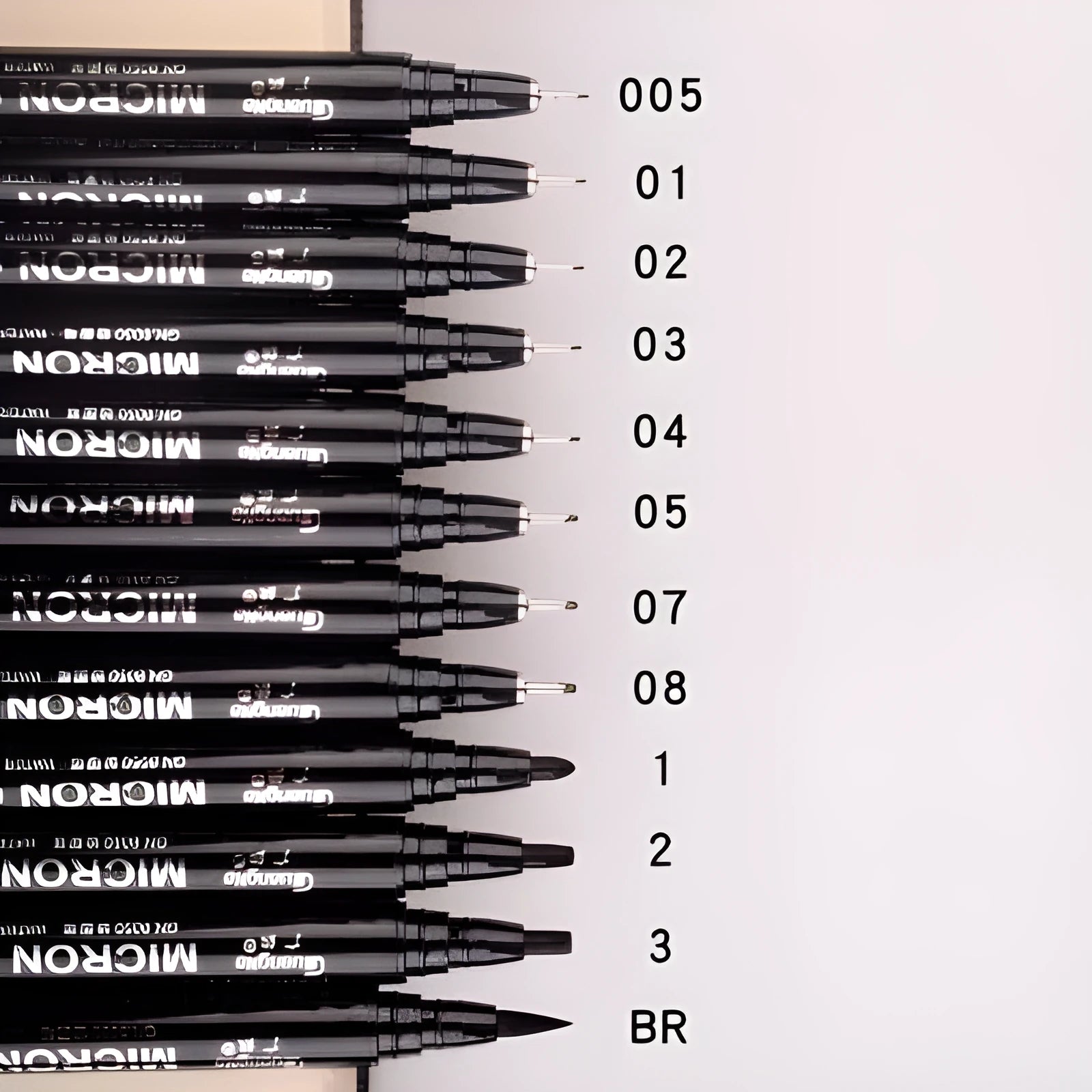 Set of 12 black comic drawing pens with various nib sizes stored in a fabric organiser bag.