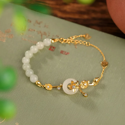 Antique style women's bracelet with peace buckle, inlaid Hetian jade lotus, on a silver chain.