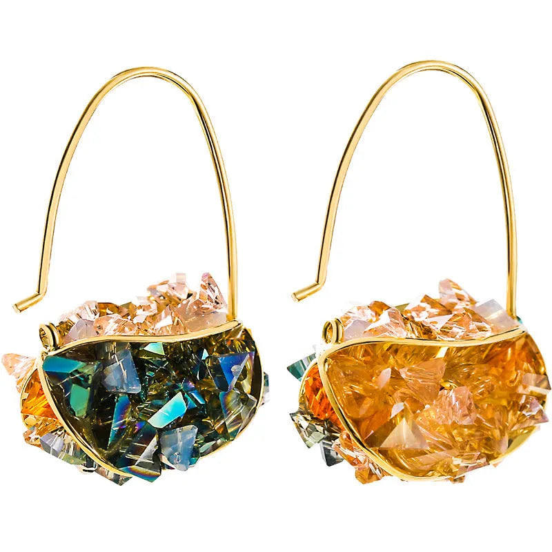 Pair of champagne gold geometric quadrilateral drop earrings on a neutral background