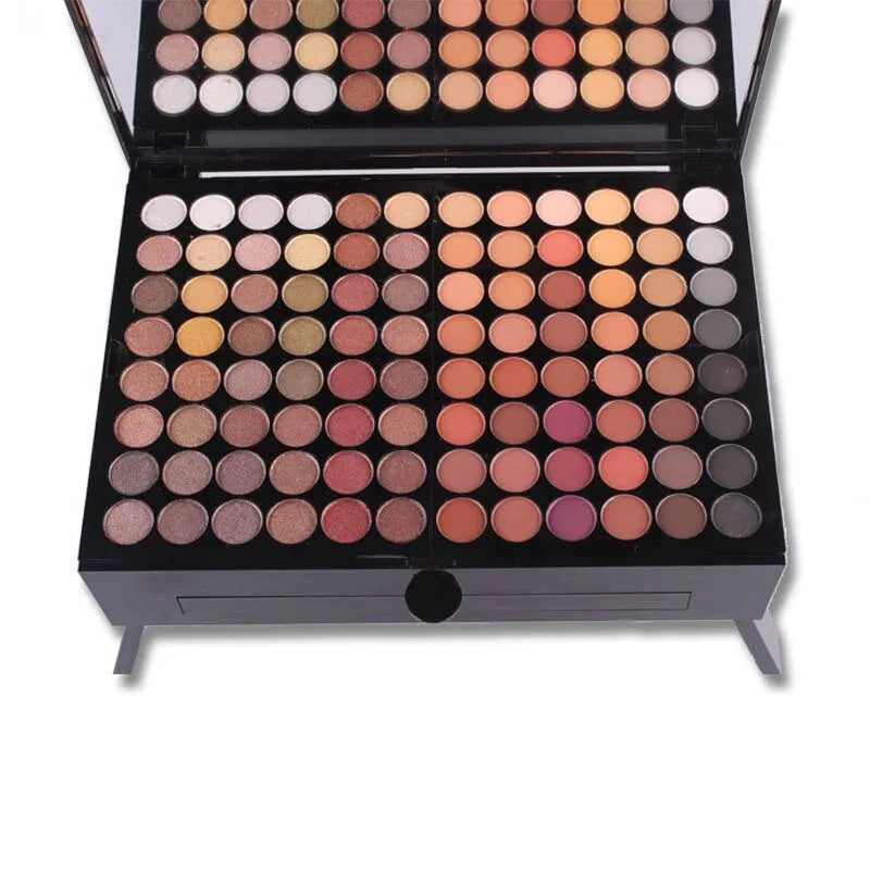 Piano-shaped open makeup palette showing 180 eyeshadows, blushers, and face powders