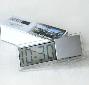 Dot matrix LCD car clock with suction cup on dashboard showing time and date