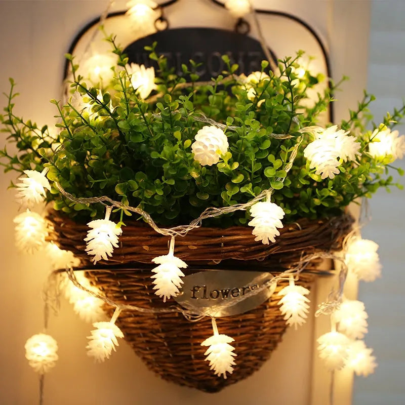 Warm white LED pine cone fairy lights on a string, battery-powered for indoor and outdoor decorative use.