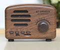 Compact vintage-style wood grain finish Bluetooth speaker on a wooden table.