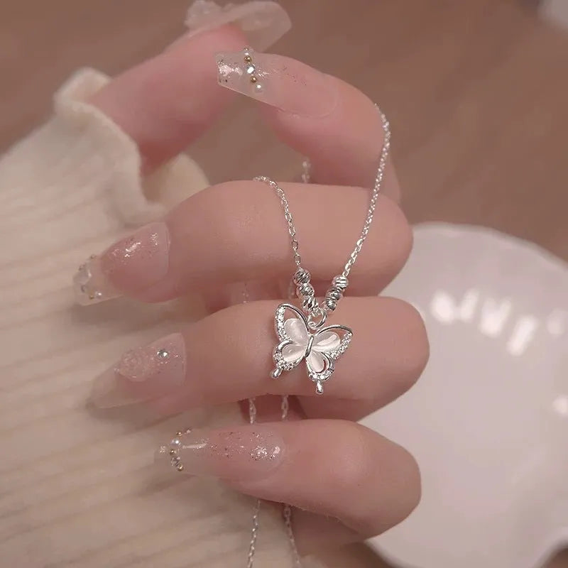 Women's silver butterfly necklace with opal detail on a cross chain, adjustable from 41cm to 50cm.