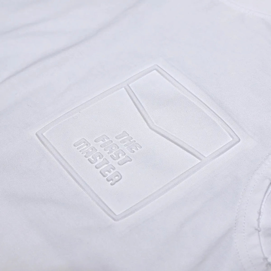 Women's loose fit cotton sleeveless vest in white on a hanger, showing straight hem and solid colour.