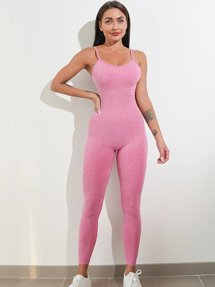 A woman wearing a black sleeveless, backless unitard jumpsuit with thin spaghetti straps.