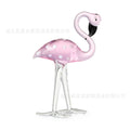 Pink crystal flamingo decorative figure on a table in modern style.