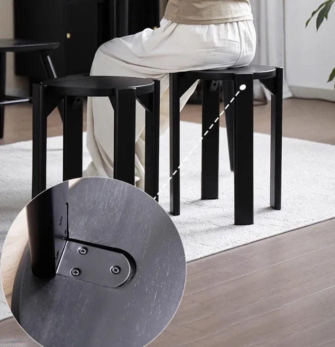 Modern round iron dining stool with stackable design in a wood-tone finish.