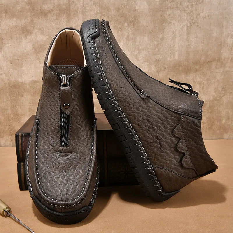 Men's black slip-on loafers with round toe and rubber sole on a plain background.