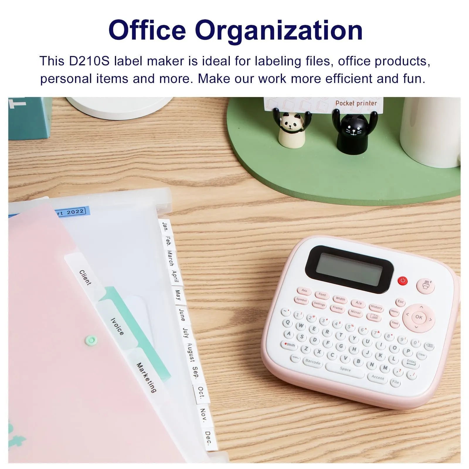 Mini portable ink-free Bluetooth label printer in pink with label tape roll, UK AC adapter, and user manual on a desk