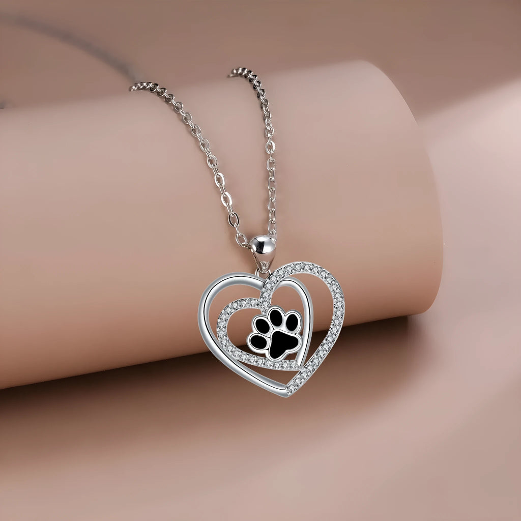 Women's copper dog paw print heart necklace on a cross chain.
