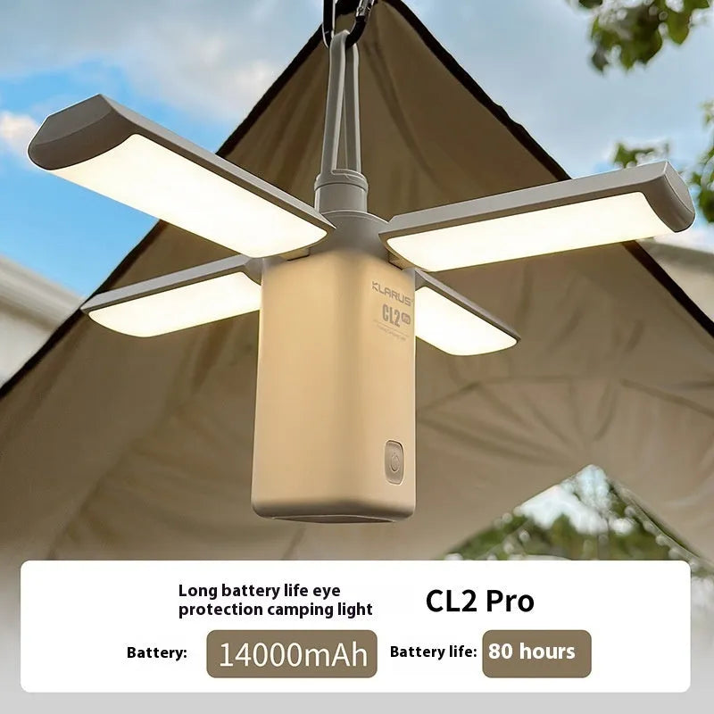 White and green rechargeable LED campsite lamp with charging cable on outdoor picnic table.