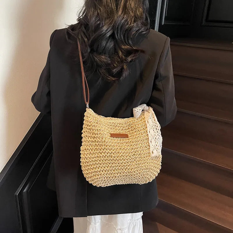Women's woven straw messenger bag with hollowed design in khaki colour showing vertical square shape