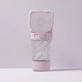Green 3-in-1 portable pet water bottle with food container and waste bag dispenser held by hand.