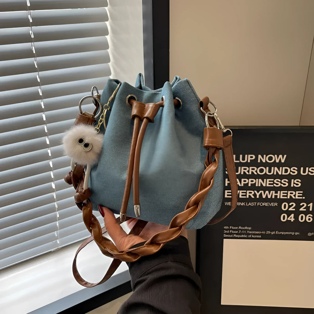 Blue one-shoulder cross body bucket bag with sandwich pocket design and messenger styling