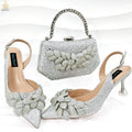 Party shoes and bag set with wine glass heel, rhinestone decoration, and buckle fastening in silver colour