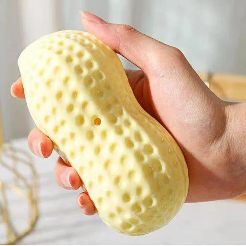 Yellow peanut-shaped dog chew toy with textured surface and squeaker