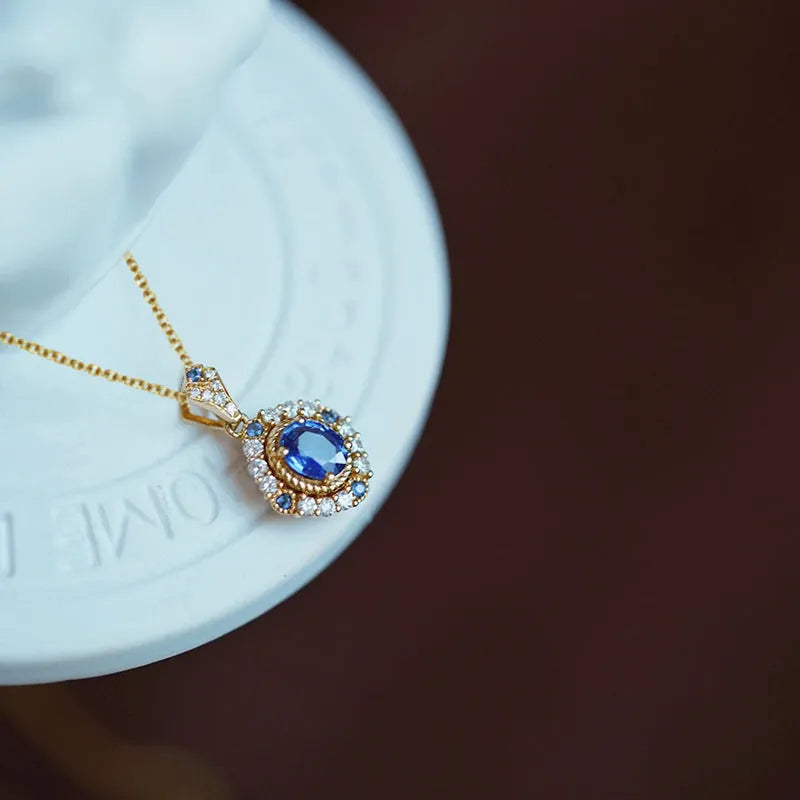Yellow gold-tone women's necklace with adjustable box chain and a gemstone pendant featuring a central inlaid zircon.