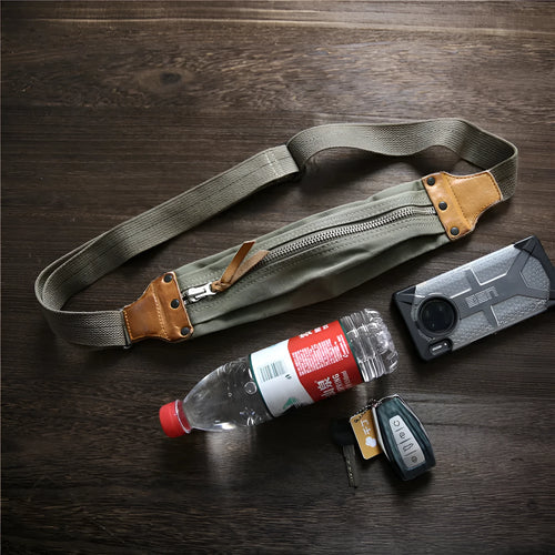 Green military style chest bag made from canvas with leather accents and anti-theft functionality