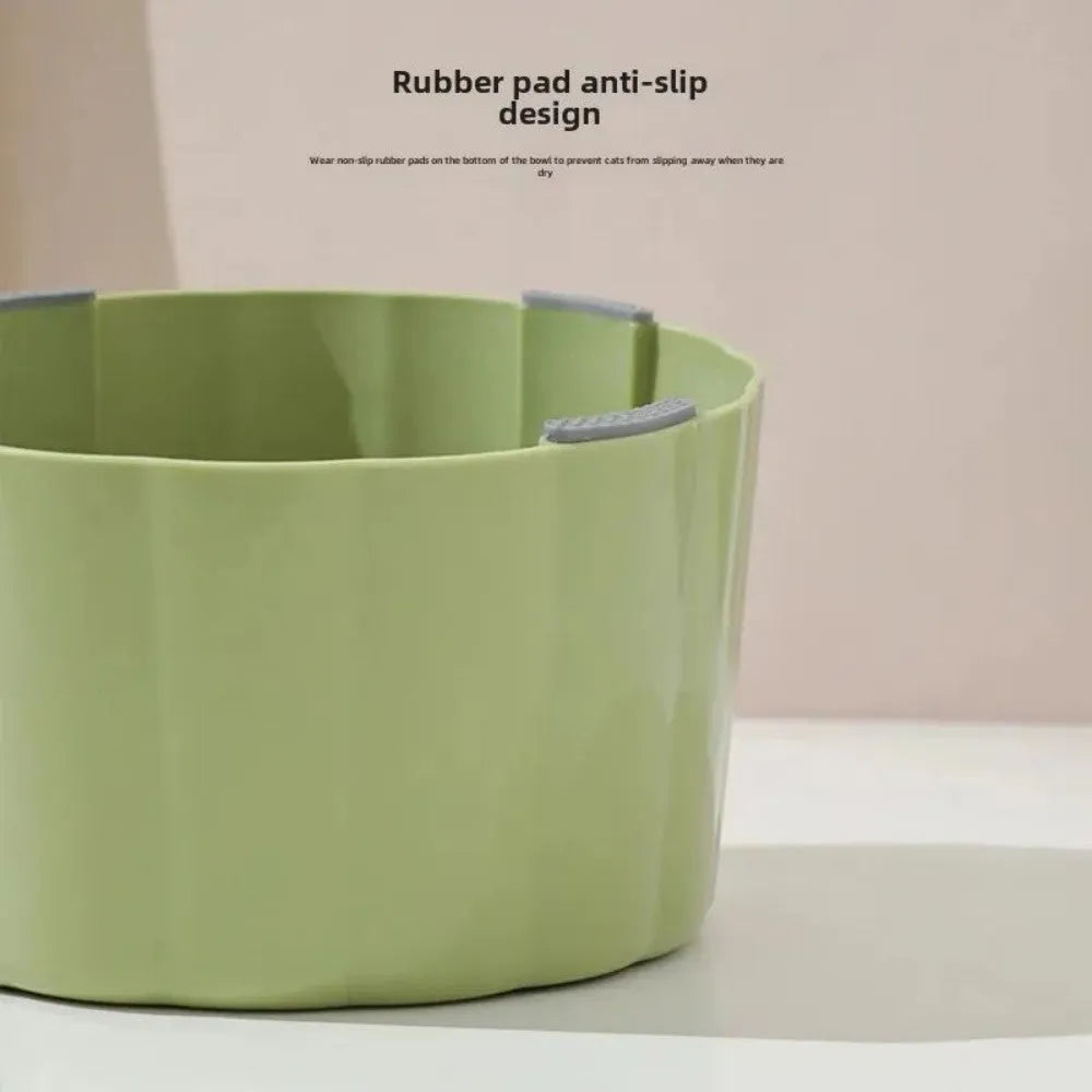Solid green cat bowl with cactus pattern and anti-slip base on a kitchen floor.