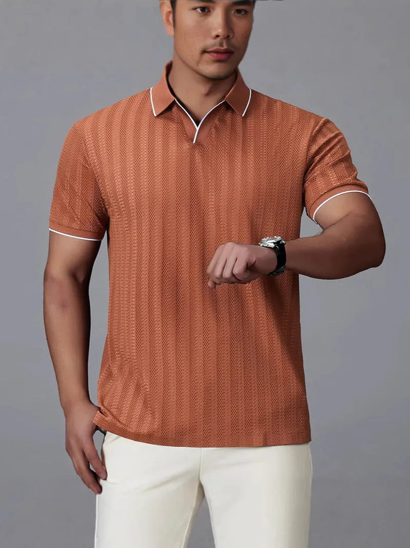 Man wearing a black loose-fit short-sleeved nylon polo shirt on a casual background.