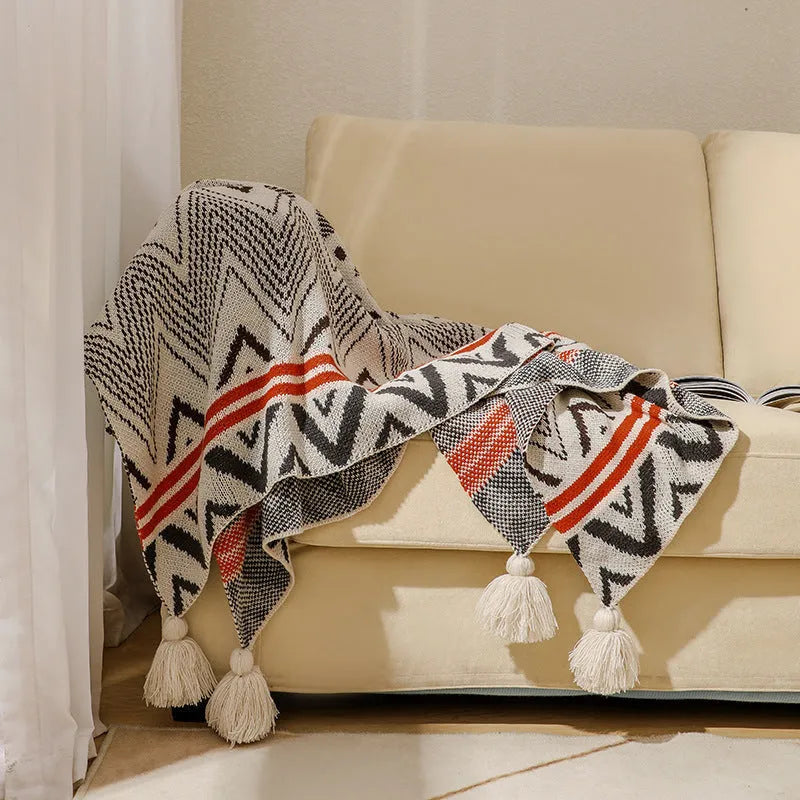 Bohemian style acrylic sofa cover blanket with tassel trim in a geometric pattern colour option.