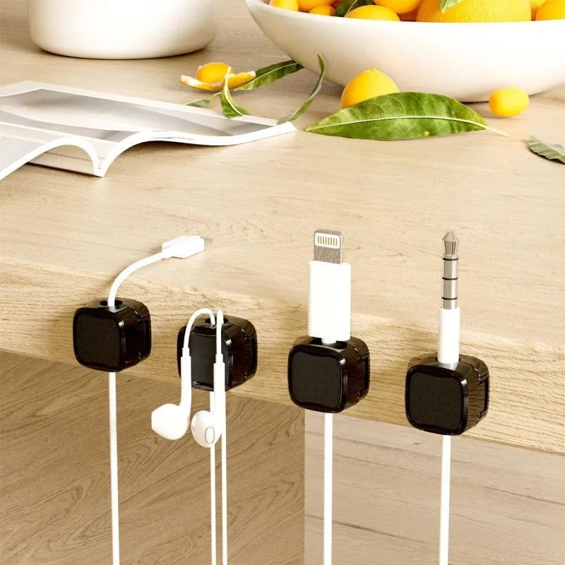 Black and white magnetic cable clips with adhesive backing for under desk cable management.