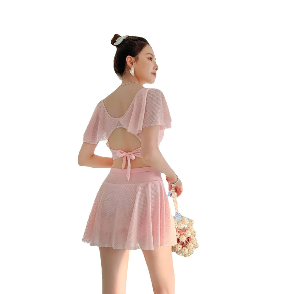 Women's solid colour two-piece swimsuit with a skirt, shown in white, black, and pink.