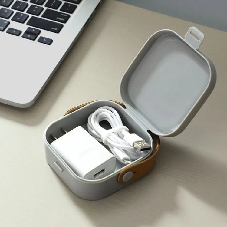 Medium-sized solid colour portable storage box for organising data cables and a Bluetooth headset.