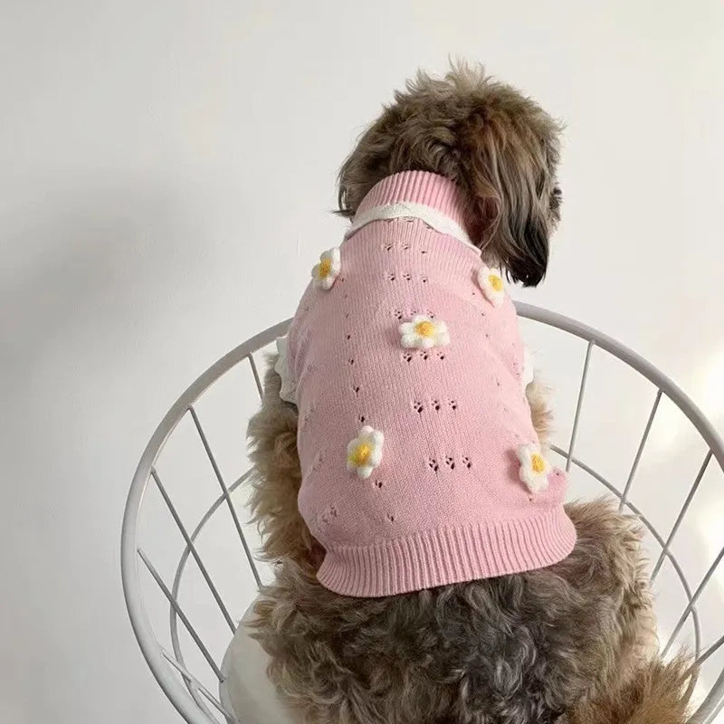 Green knitted sleeveless dog sweater vest with flower pattern on a small dog.