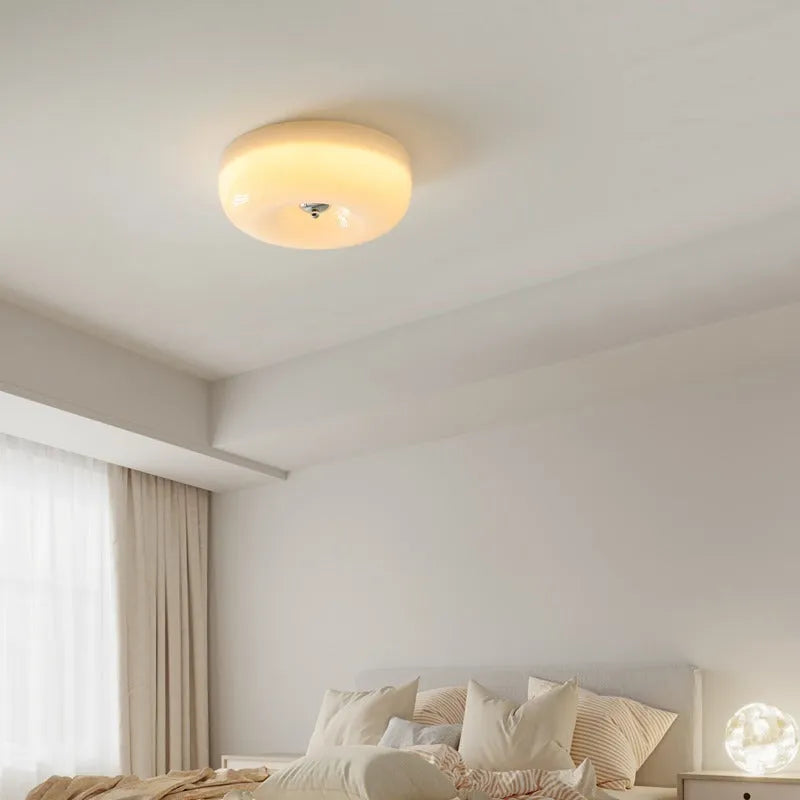 American style cream coloured bedroom ceiling light with a remote control on a white background.