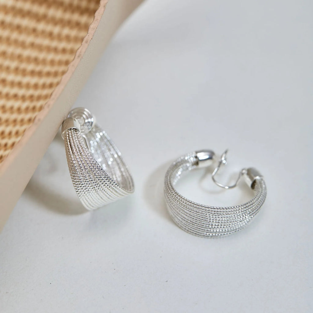 Geometric multi-layer copper earrings with silver or gold electroplated finish, available as studs or clips