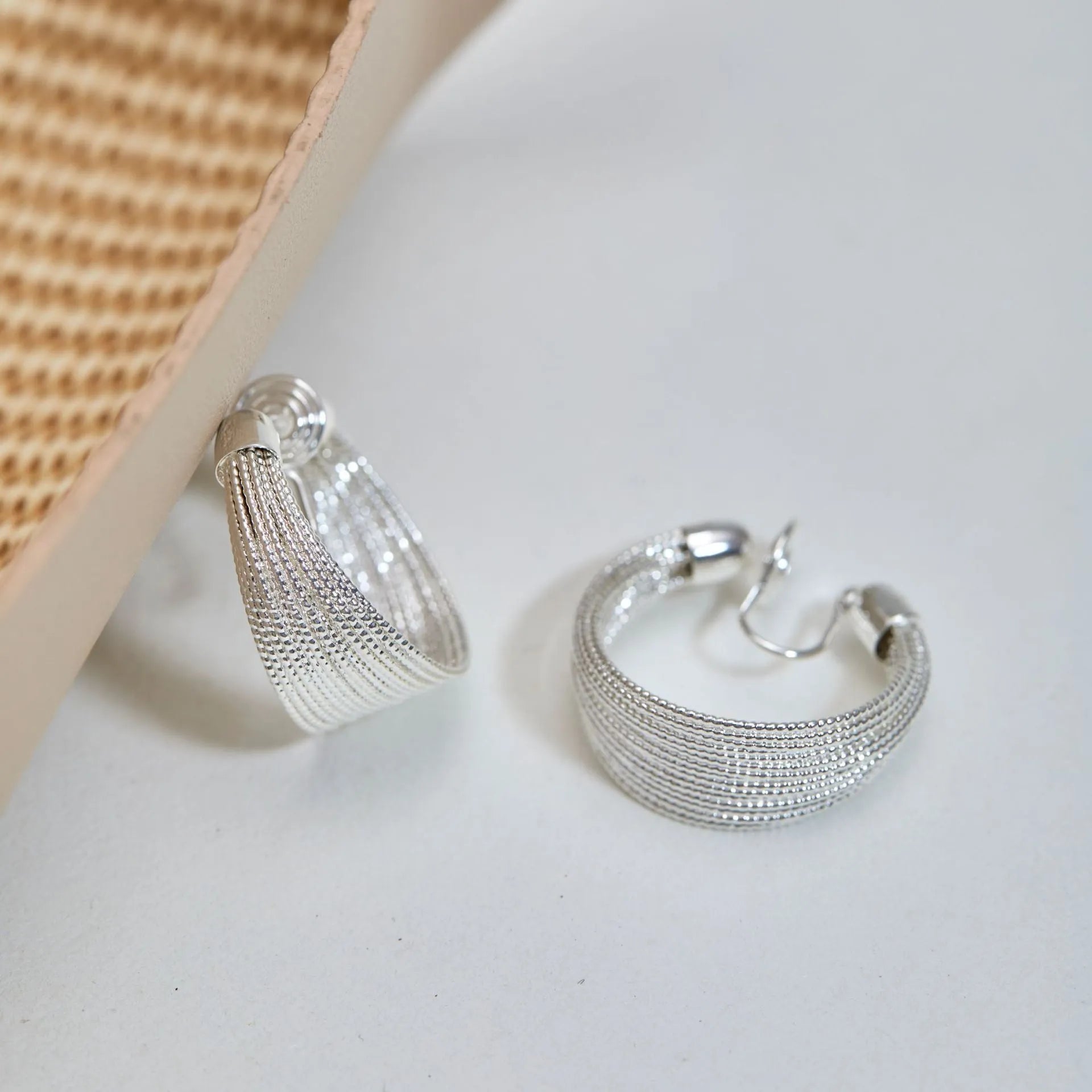Geometric multi-layer copper earrings with silver or gold electroplated finish, available as studs or clips