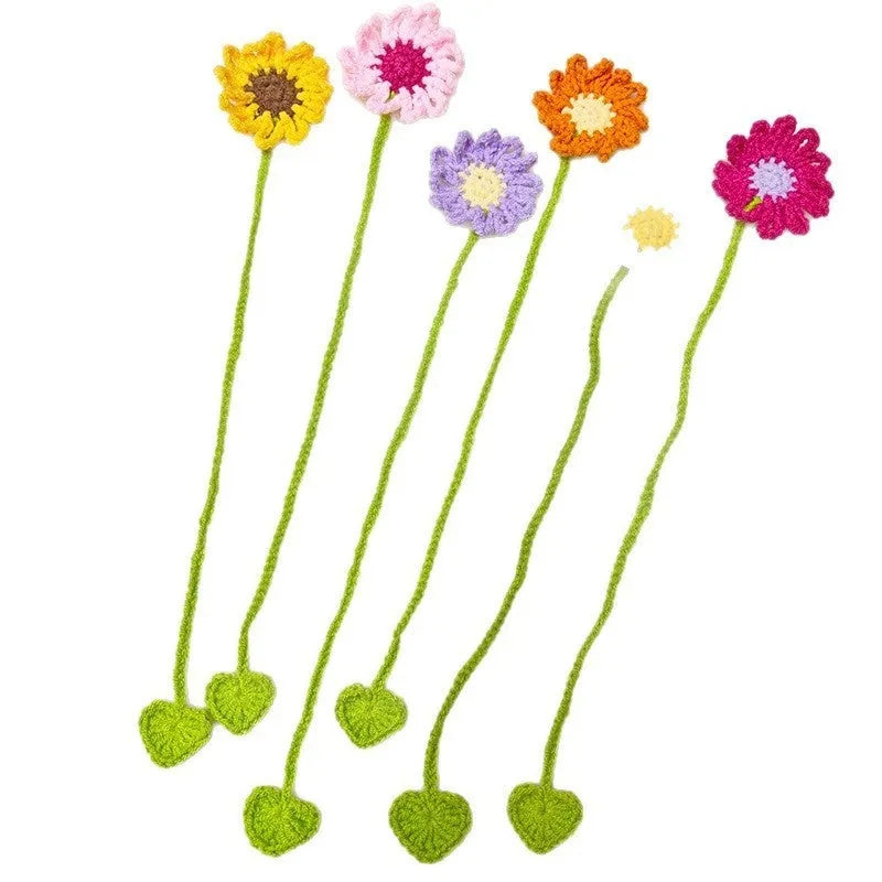 Hand-crocheted daisy bookmark made from flexible milk cotton wire in assorted colours on an open book.