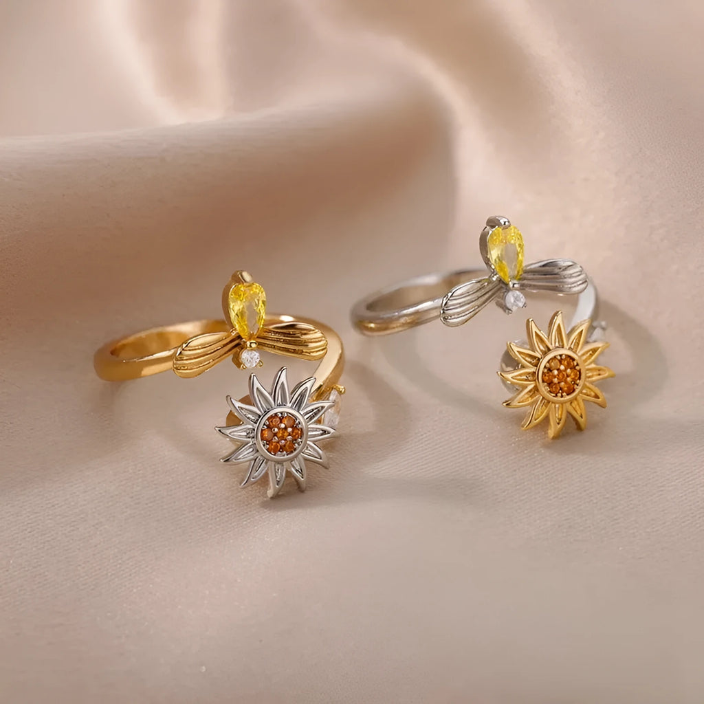 A geometric gold-coloured ring with an adjustable opening, shown rotating on a finger.