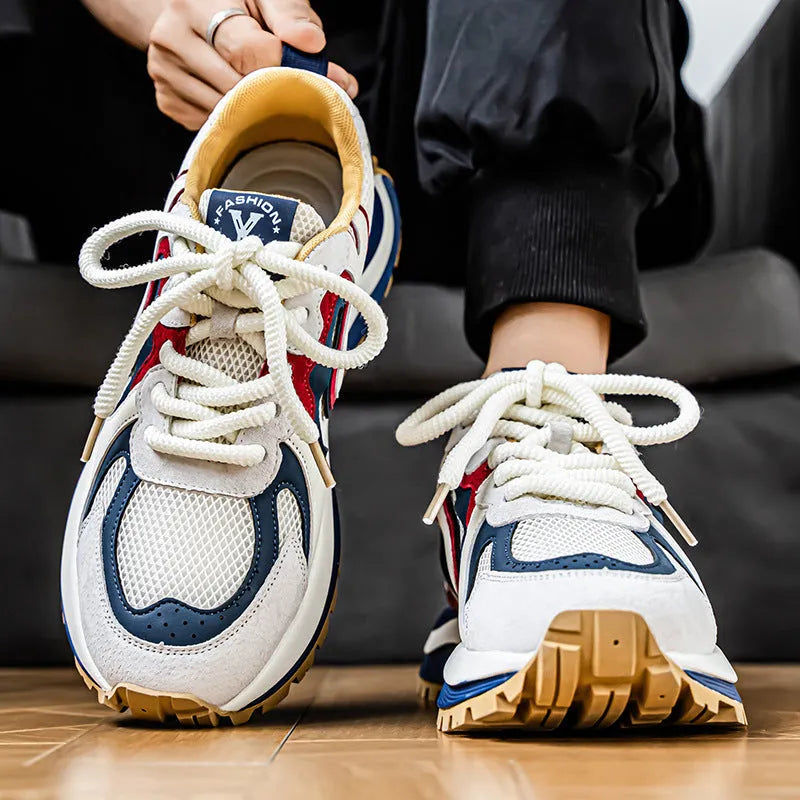 Men's casual sneaker in synthetic leather and mesh, showing round toe and lace-up front.