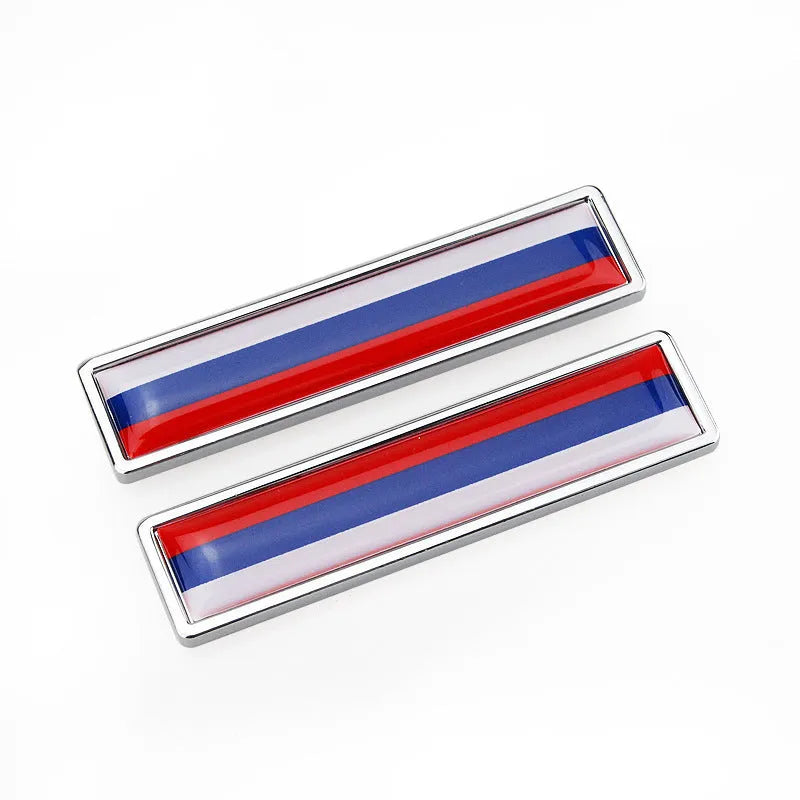 Pair of rectangular zinc alloy metal car badge stickers showing national flag designs, dimensions 58mm by 14mm.