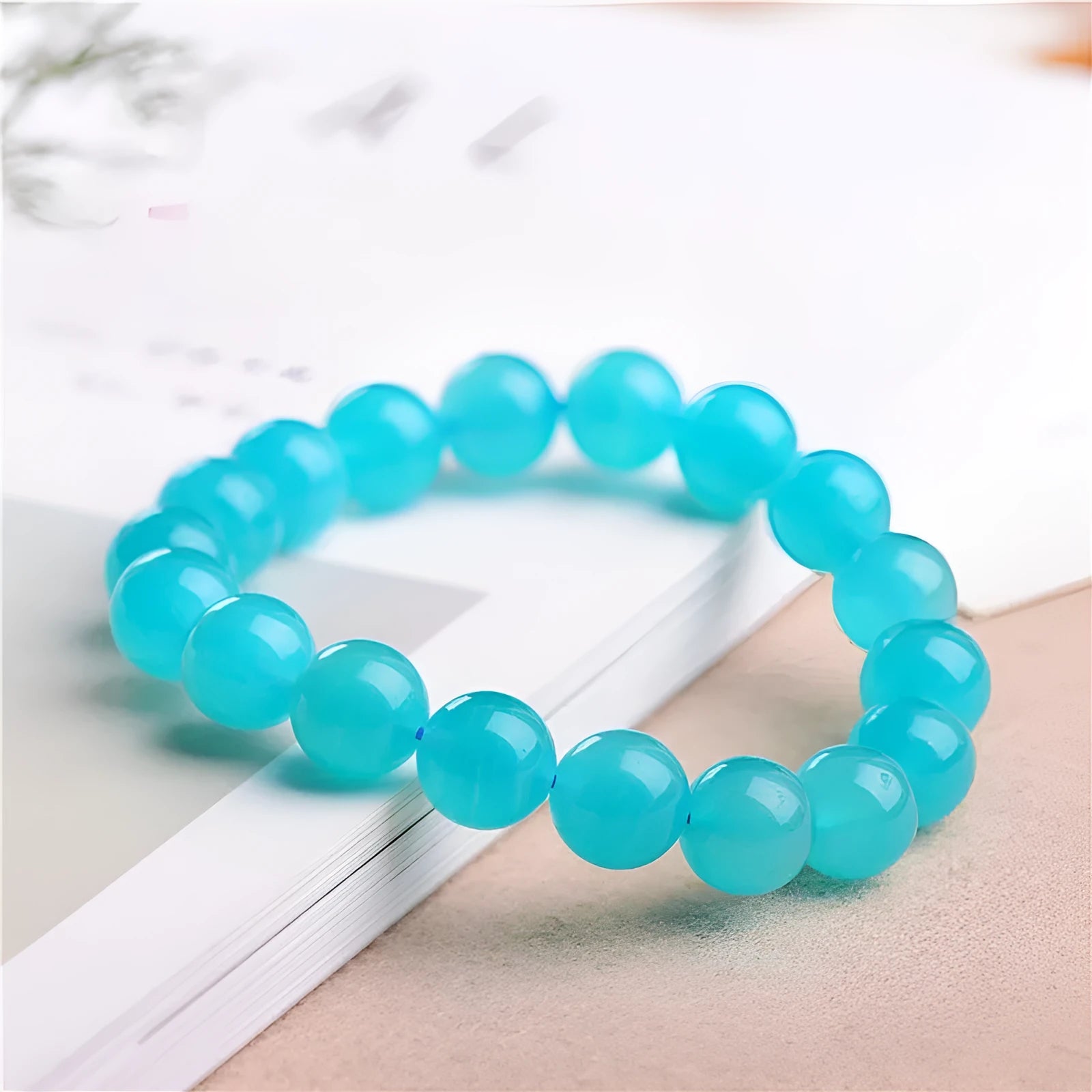 Loose natural green Amazonite beads in various sizes for jewellery making on a white surface.