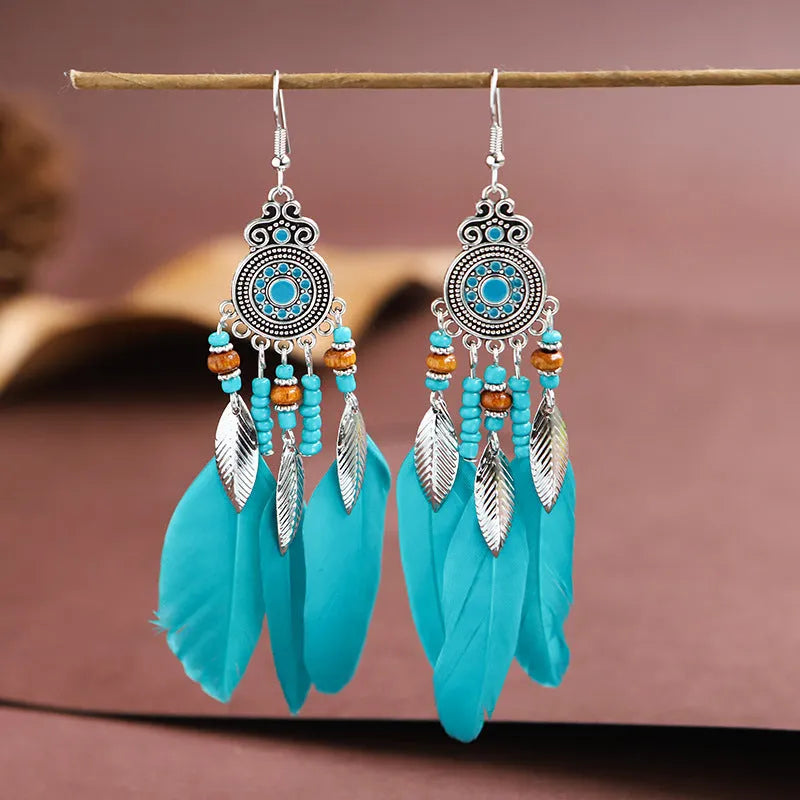 Round drop feather earrings in alloy with electroplated finish showing leaf shape and pattern details