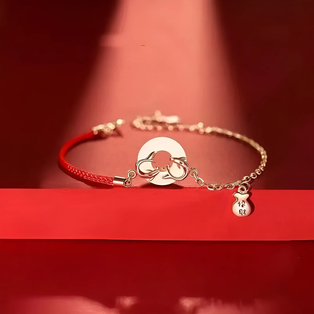 Close-up of a red rope festive koi bracelet for women with a peace buckle and fish tail details.