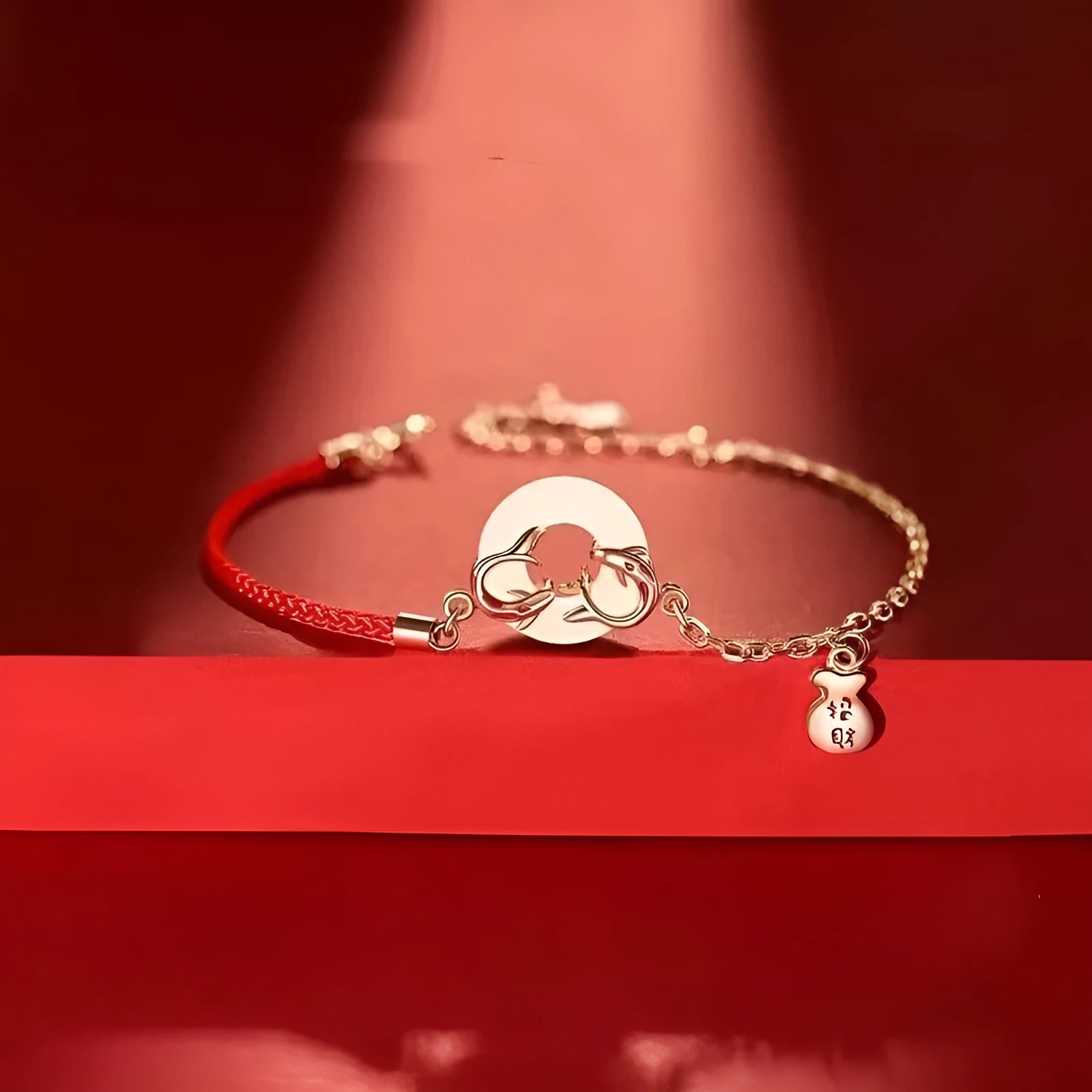 Close-up of a red rope festive koi bracelet for women with a peace buckle and fish tail details.