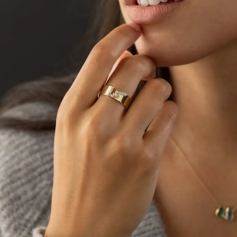 Gold plated women's ring with a shining zircon stone on a model's hand.