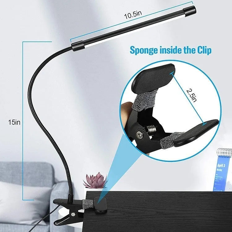 Black and white USB-powered LED desk lamp with a 26 cm long base on a wooden desk.